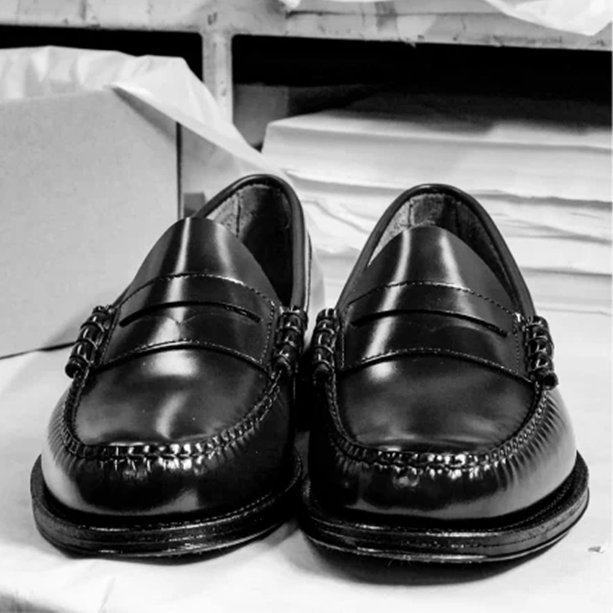 A black and white image of a pair of black loafers