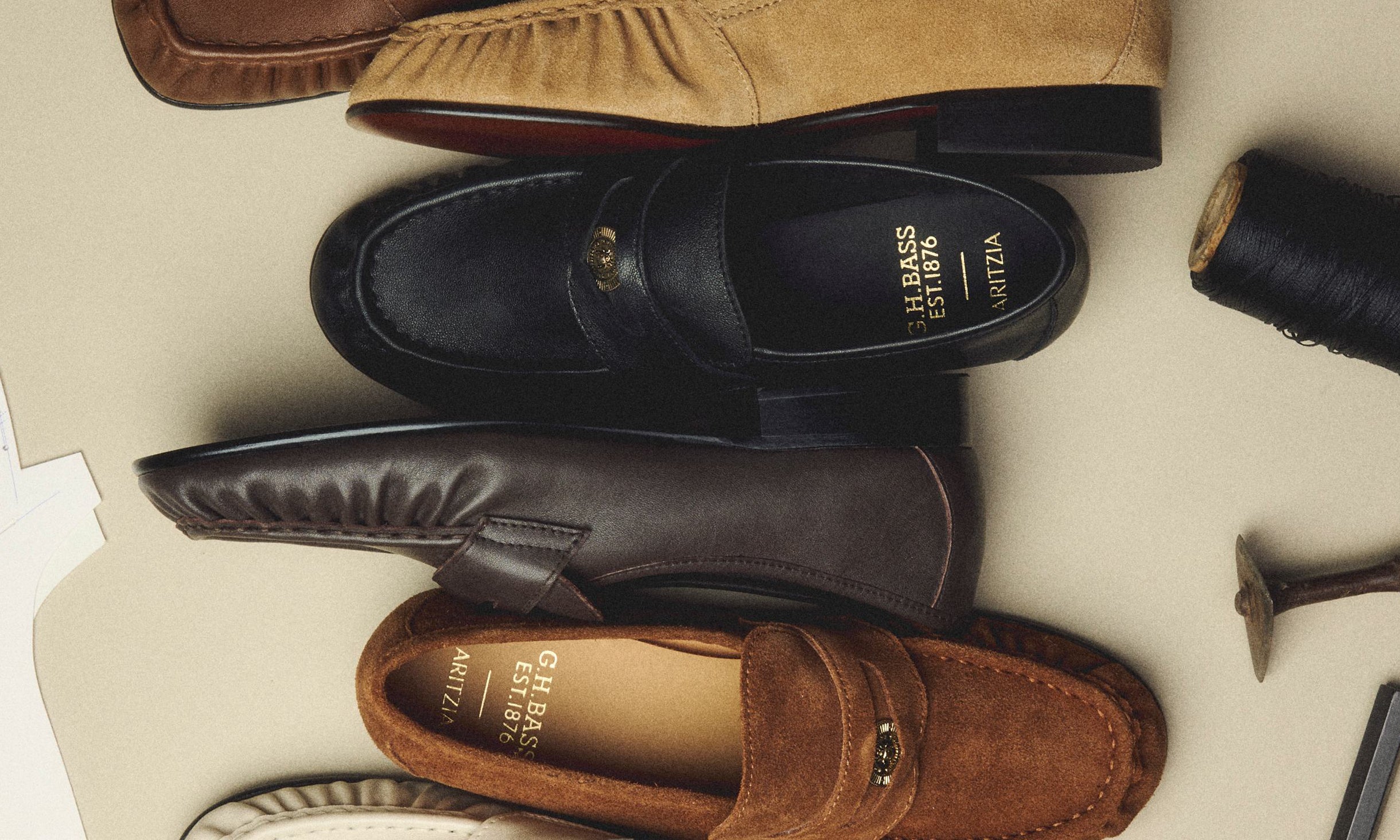 Brown, black, and beige suede and leather loafers displayed against a pale beige background