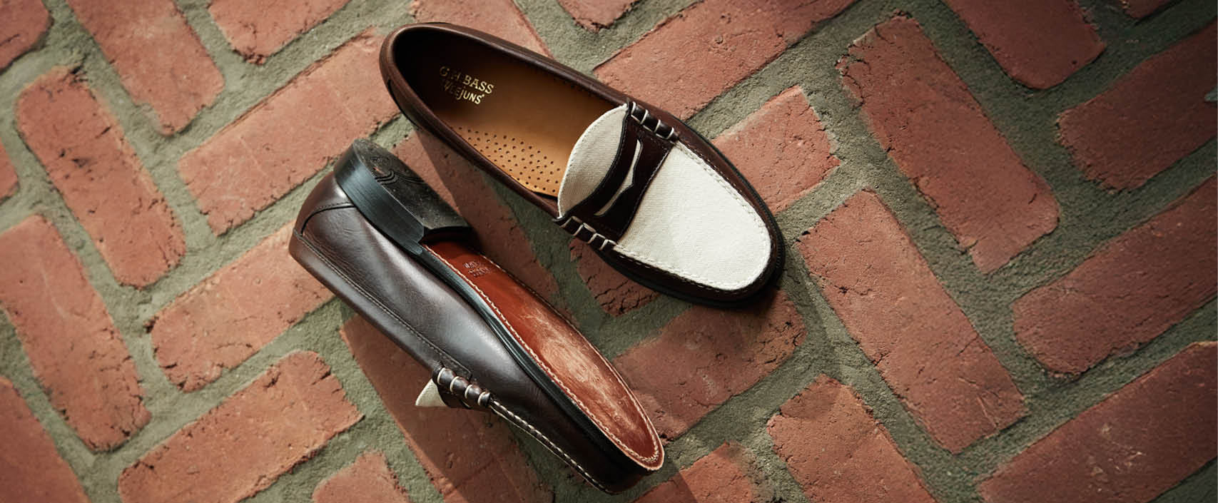 A pair of brown and white loafers on a red brick floor