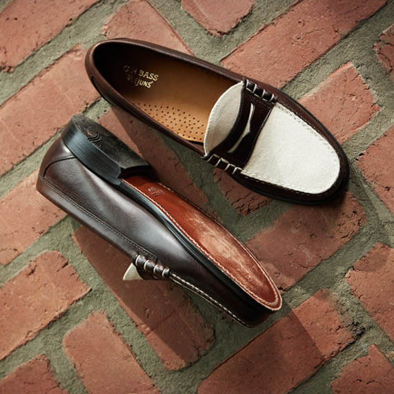 A pair of brown and white loafers on a red brick floor